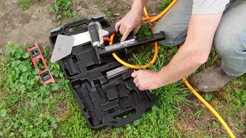 Man loading pneumatic nail gun before start working, close up 動画素材 230440405