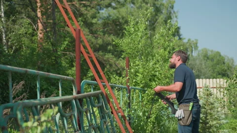 Man loading pneumatic rifle after chasing bird near garden fence Stock Footage 318033125