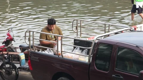 A man loading a purchase from a flooded market Stock Footage 223377277