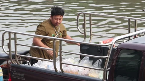 A man loading a purchase from a flooded market Stock Footage 227103099