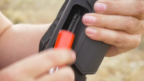 Man Loading a Red Shell into a Pump Action Shotgun in Slow Motion Stock Footage 87847659