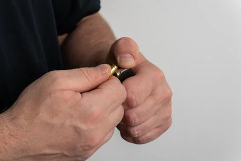 Man loading rubber bullet cartridge into pistol magazine close up Stock Photos