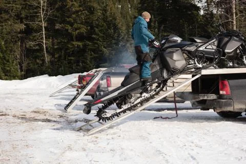 Man loading snowmobile on van Stock Photos