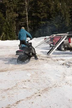Man loading snowmobile on van Stock Photos