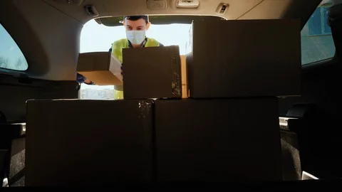 Man loads boxes of medicines in the trunk of the car Stock Footage 127891389
