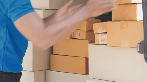 Man loads cardboard boxes for delivery service into a delivery van Stock Footage 325447391