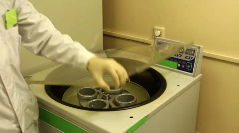 A man loads,  closes and starts centrifuge Stock Footage 58400540
