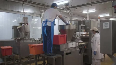 A man loads curd into a shaping machine Stock Footage 161510583