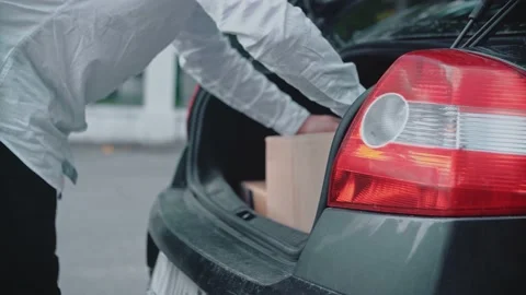 A man loads parcels, puts cardboard boxes in the trunk of a car. 스톡 동영상 150156717