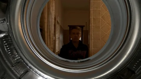 A man loads a washing machine, close up view from inside Stock Footage 103165796