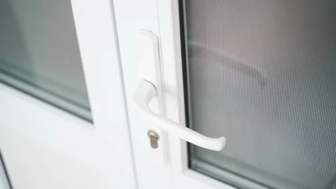 A man locked inside pulls on the handle of a white plastic door. Trapped person Stock Footage 219515713