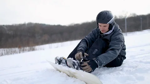Man Locking Boots on Snowboard for Skiing 動画素材 103759144