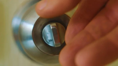 A man locking a stainless doorknob turning it clockwise  - Extreme close up Stock Footage 122137695