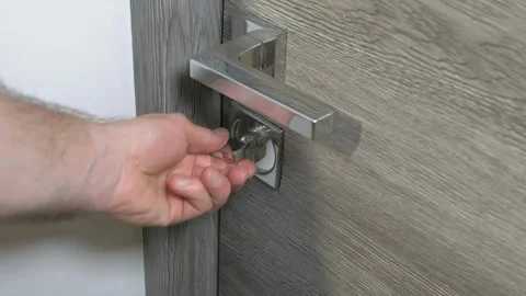 A man locks a door, a night light on the door in the house Vidéo 336466328