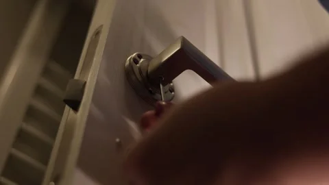 Man locksmith repairs an interior wood door in bath room Stock Footage 343801613