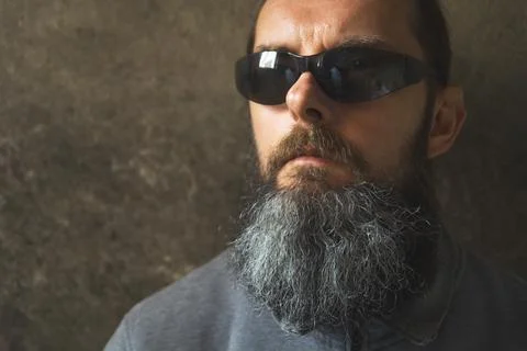 A man with a long beard on the background of the wall Stock Photos