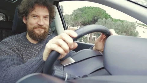 Man with long beard driving looking camera smiling ok sign slow motion Stock Footage 71273234