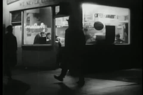 Man in long coat walking through city at night Stock Footage 25195454