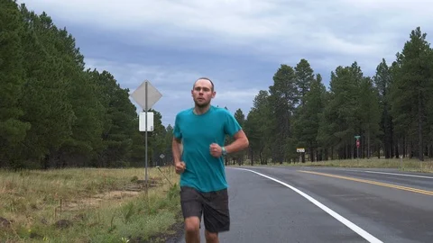 A man long distance running down a country road Stock Footage 95964321