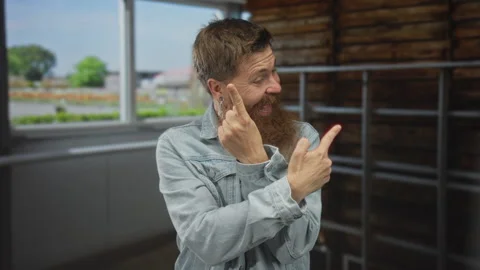 Man with long ginger beard pointing both index fingers to the side in brigh.. Stock Footage 314627049