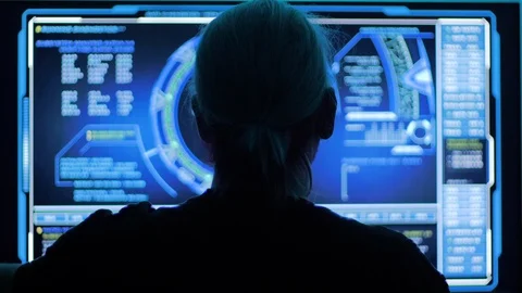 Man with long hair looking at data on massive computer monitor Stock Footage 118976893