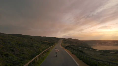 Man on longboard ride empty road at sunset Video stock 145830504