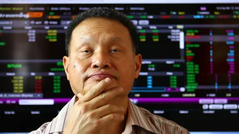 Man look and thinking  about  stock price on board, blurred stock exchange board Stock Footage 151890041