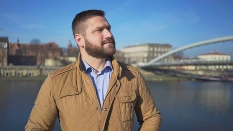 Man look around, on the background of the river and footbridge, outdoor 库存影片 72709124