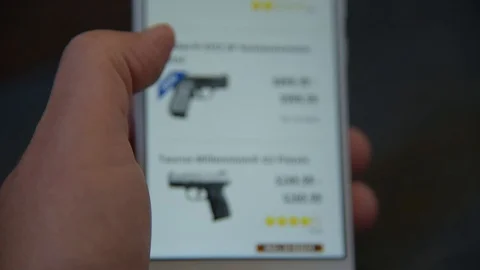 A man looking and chooses a weapons to buy on the site. Stock Footage 107762274