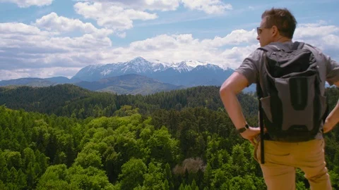 Man looking at awesome panorama mountains with snow peaks on top Stock Footage 107931473