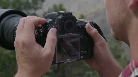 Man looking at back of camera then shooting Stock Footage 54708754