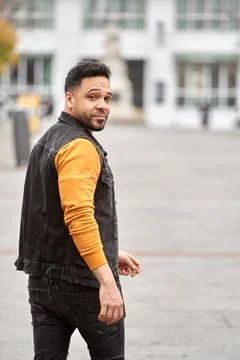 Man looking back while walking outdoors on the street. 스톡 사진