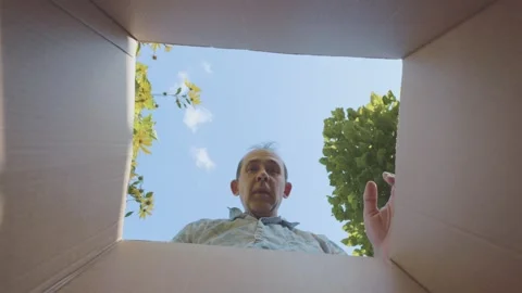 Man looking into a box, surprised with hand on forehead, expressing awe out.. Stock Footage 295194484