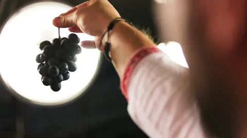 Man looking at a bunch of grapes Stock Footage 172484512