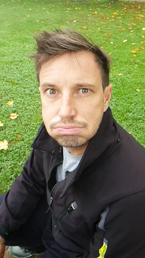 A man looking at a camera and doing a horse gimace in slowmotion. Outside 스톡 동영상 143374986