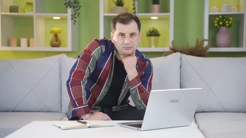 Man looking at camera and sighing while looking at laptop in a languid. Stock Footage 232286484