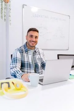 Man looking at camera and smiling while working in the office. 스톡 사진