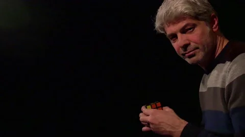 A man looking into camera and solves the Rubik's cube Stock Footage 63209128