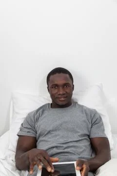 Man looking at camera and touching his tablet. Foto stock