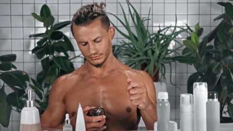 Man looking at camera and using perfume in bathroom Stock Footage 140759740