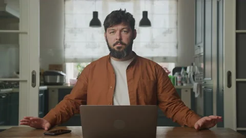 Man looking at camera and waiting in front his laptop Stockbeeldmateriaal 199247927