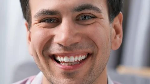 Man looking at camera close up. Happy handsome guy. Perfect white teeth smile. Stock Photos