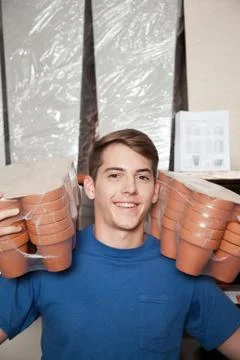 Man looking at the camera with flower pots Stock Photos