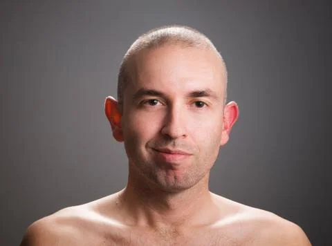 Man looking at camera with a half smile Stock Photos