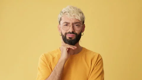 Man looking at camera listens carefully and disagree, isolated on yellow Stock Footage 255964416