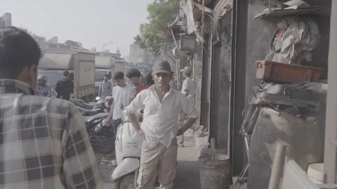 A man looking at the camera on a main street in Mumbai, India Stock Footage 345387854