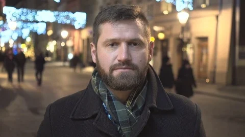 Man looking at camera at night in city Christmas time close Steadicam shot  Vídeos de archivo 72781719