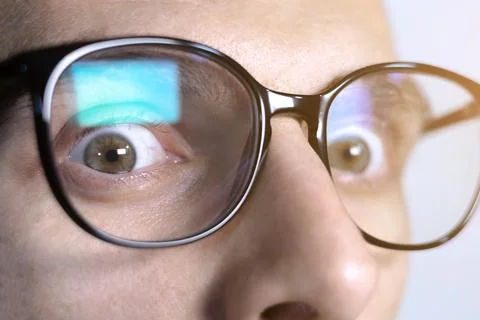 Man looking in camera. Reflection at the glasses from laptop...Close up of .. Stock Photos