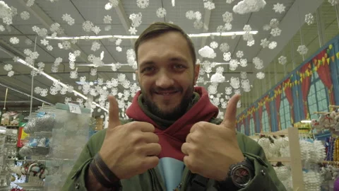 Man looking at camera showing thumbs up on christmas holidays with christmas hol Видео 142696586