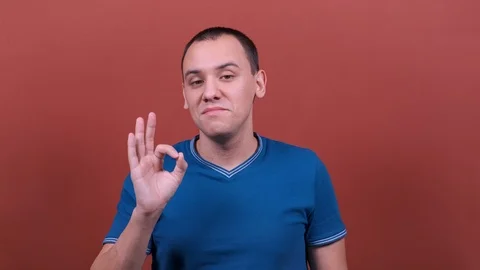 Man Looking at the camera with smile, showing OK gesture. man emotion isolated Stock Footage 123017246
